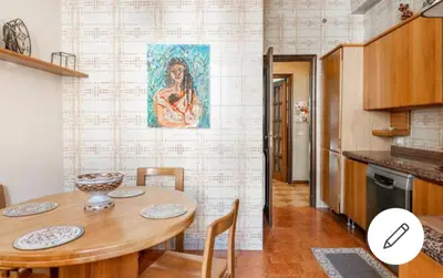 a dining room with a table and a painting on the wall at Le stanze di Nonna Maria in Palermo
