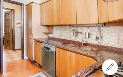 a kitchen with wooden cabinets and stainless steel appliances at Le stanze di Nonna Maria in Palermo