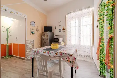a dining room with a table and a refrigerator at Casetta Holiday Meli in Palermo