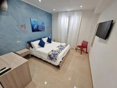 a bedroom with a bed and a flat screen tv at Corallo Rosso B&B in Terrasini