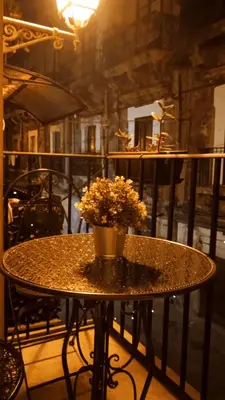 a table with a vase of flowers on a balcony at Arco Cutò casa vacanze in Palermo