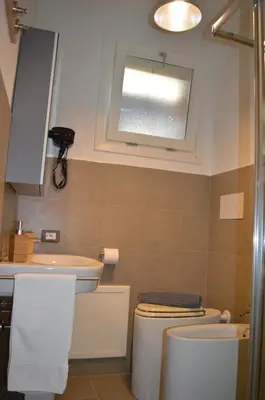 a bathroom with a sink and a toilet and a window at Arco Cutò casa vacanze in Palermo
