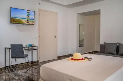 a room with a bed with a hat and glasses at Suite Altamarea 