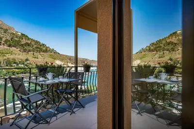 a table and chairs on a balcony with mountains at Suite Altamarea 