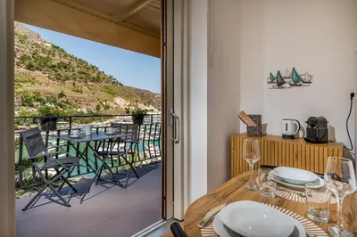 a dining room with a balcony with a table and chairs at Suite Altamarea 