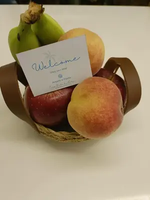 a basket of fruit with a sign on it at Cozy Suite&Lodge Mondello beach in Palermo