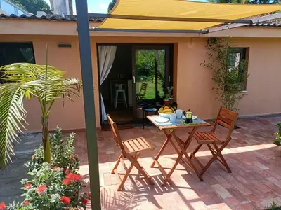 a patio with a table and chairs under a yellow umbrella at Cozy Suite&Lodge Mondello beach in Palermo