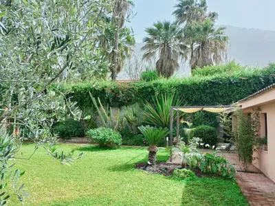 a backyard with a garden with trees and plants at Cozy Suite&Lodge Mondello beach in Palermo