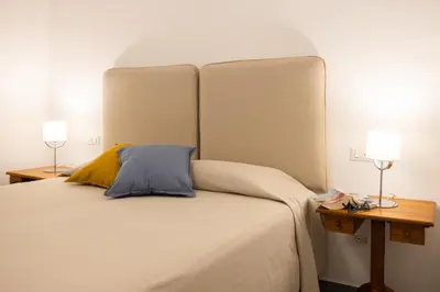 a bedroom with a large white bed with two lamps at Cube 67 - Garden in Palermo