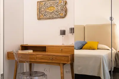 a bedroom with a bed and a desk with a mirror at Cube 67 - Garden in Palermo