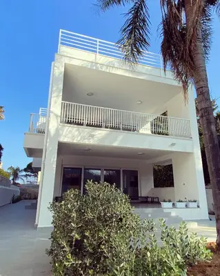 a white house with a balcony and a palm tree at Cube 67 - Garden in Palermo