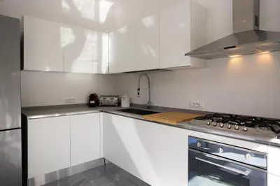a kitchen with white cabinets and a sink at Cube 67 - Terrace in Palermo