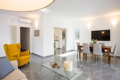 a living room with a table and a yellow chair at Cube 67 - Villa in Palermo