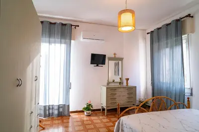 a bedroom with a bed and a dresser and windows at A casa di Mara in Mondello