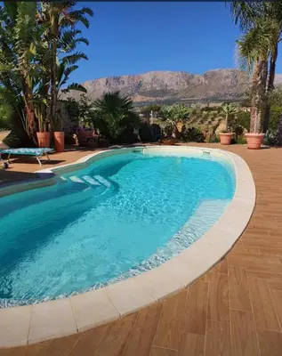 a swimming pool in a resort with mountains in the background at Villa Dorotea con piscina in Trappeto