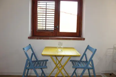 a yellow table with two blue chairs and a window at Terrasini 2000 Home Holidays in Terrasini
