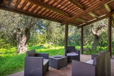 a patio with chairs and a table under a pergola at Villetta Rosamarina by Wonderful Italy in Cefalù