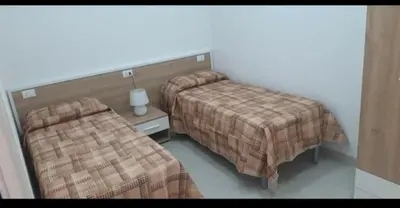a hotel room with two beds and a table with a lamp at A Casa Ri Angela in San Vito lo Capo