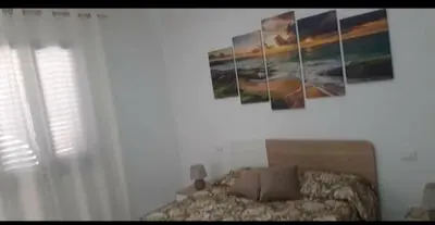 a bedroom with a bed and paintings on the wall at A Casa Ri Angela in San Vito lo Capo