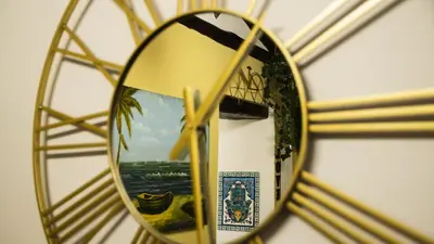 a gold clock with a reflection in a mirror at Le Maioliche Apartment in Palermo