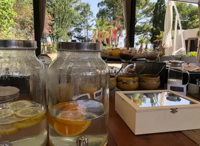 a table with two glass jars filled with water and lemonade at Araja Villa&Suite by Geocharme in San Vito lo Capo