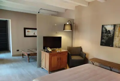 a bedroom with a bed and a chair and a television at Araja Villa&Suite by Geocharme in San Vito lo Capo