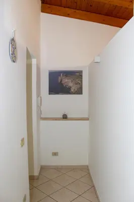 a hallway with white walls and a painting on the wall at La terra del sole in Cinisi