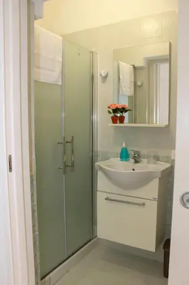 a bathroom with a glass shower and a sink at La terra del sole in Cinisi