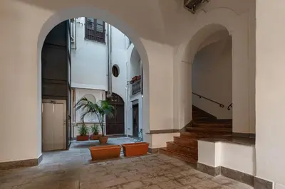 a hallway of a building with arches and stairs at Palazzo Damiani Apartment by DomuSicily in Palermo