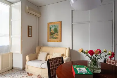 a living room with a couch and a table at Palazzo Damiani Apartment by DomuSicily in Palermo