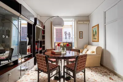 a living room with a dining room table and chairs at Palazzo Damiani Apartment by DomuSicily in Palermo