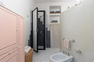 a bathroom with a sink and a toilet and a shower at Palazzo Damiani Apartment by DomuSicily in Palermo