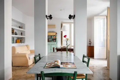 a living room with a table and a couch at Palazzo Damiani Apartment by DomuSicily in Palermo