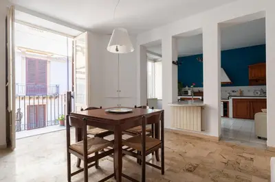 a kitchen and dining room with a wooden table and chairs at Palazzo Damiani Apartment by DomuSicily in Palermo
