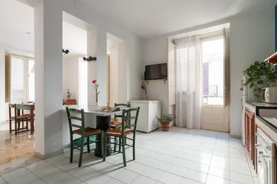 a kitchen and dining room with a table and chairs at Palazzo Damiani Apartment by DomuSicily in Palermo