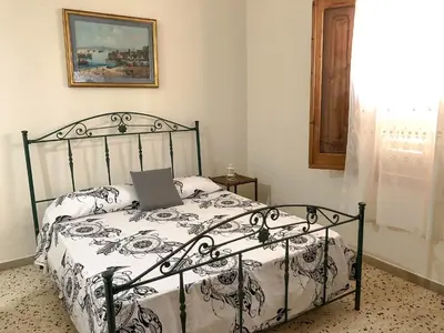 a bedroom with a bed with a laptop on it at Casa Conchiglia in San Vito lo Capo