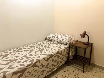 a bedroom with a bed with a lamp on a table at Casa Conchiglia in San Vito lo Capo