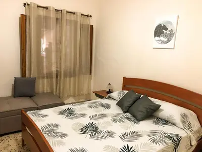 a bedroom with a bed and a couch at Casa Conchiglia in San Vito lo Capo