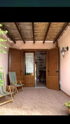 a patio with two chairs and a table in a house at Màkari in Macari