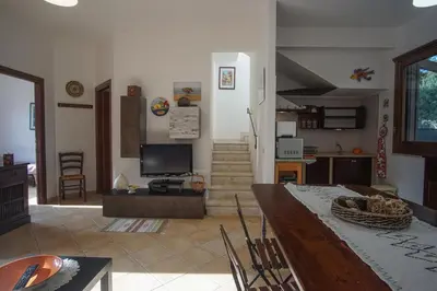 a living room with a table and a tv at Màkari in Macari