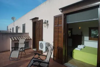 a room with a bed and two chairs on a patio at Màkari in Macari