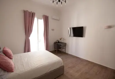 a bedroom with a bed and a flat screen tv at Aragona15 Suites in Palermo