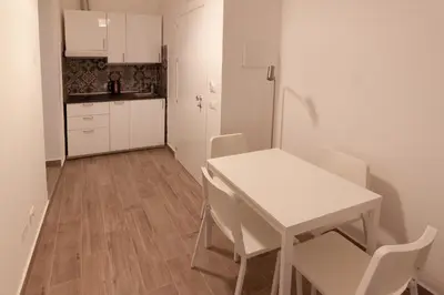 a small white kitchen with a table and chairs at Aragona15 Suites in Palermo