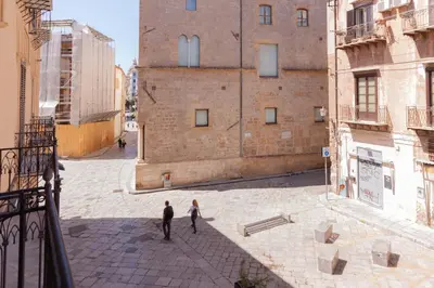 two people walking down a street in a city at Aragona15 Suites in Palermo