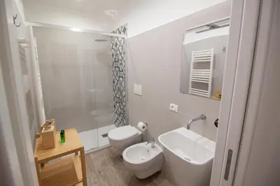 a white bathroom with a toilet and a sink at Aragona15 Suites in Palermo