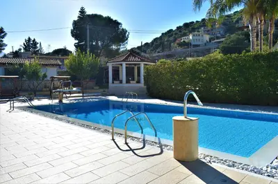 a swimming pool in front of a house at Villa Caterina in Torretta