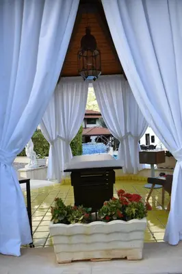 a gazebo with white drapes and flowers at Villa Caterina in Torretta