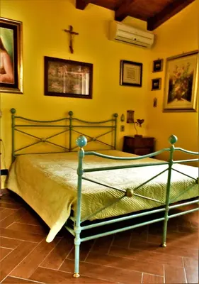 a bedroom with a bed with a cross on the wall at Villa Caterina in Torretta