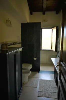a bathroom with a toilet and a sink and a window at Villa Caterina in Torretta