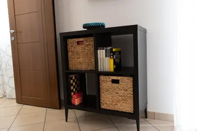 a black book shelf with baskets on it at Cassaro Casa Vacanze in Castellammare del Golfo